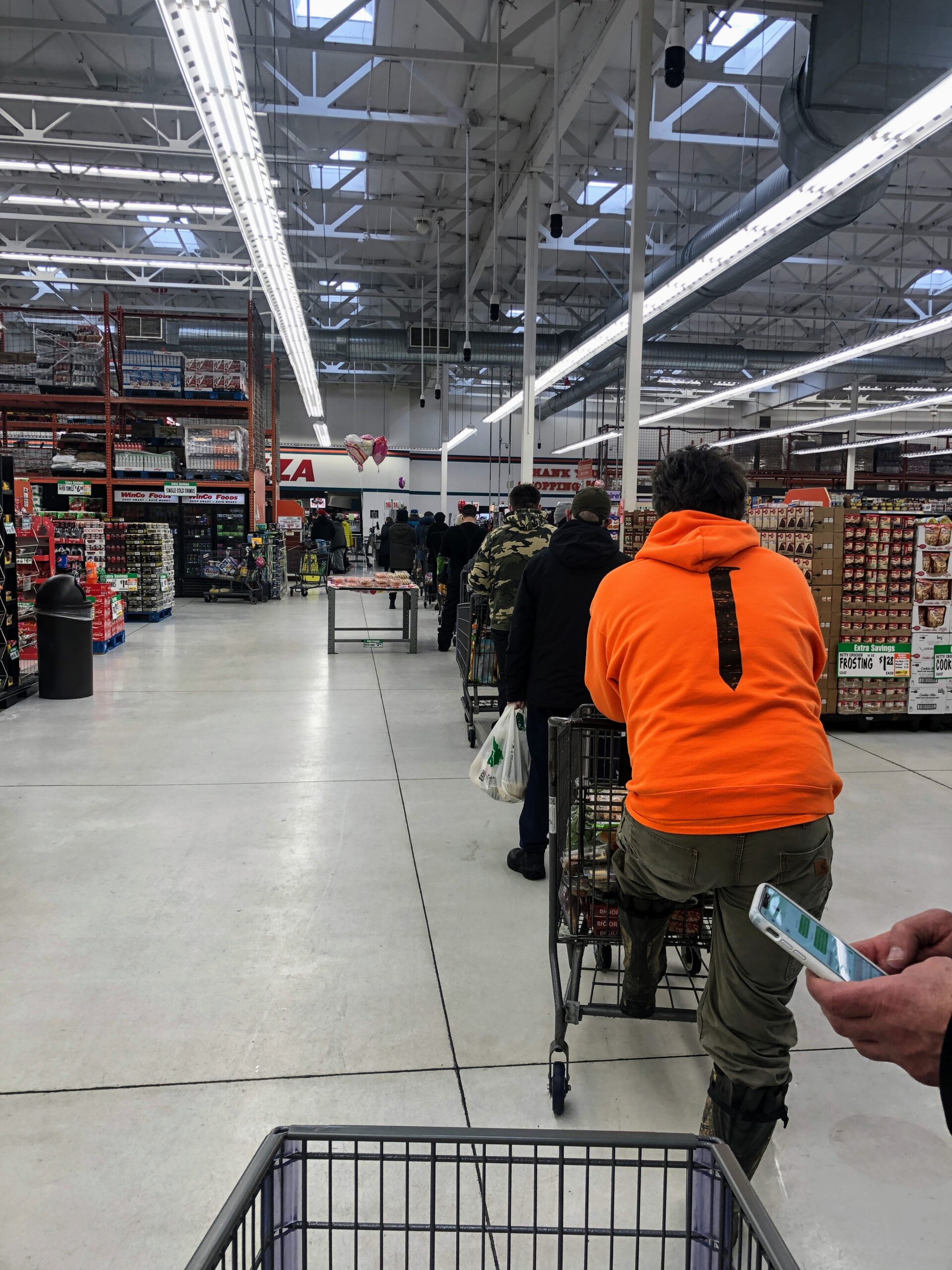 Grocery store with long line of people waiting to check out.