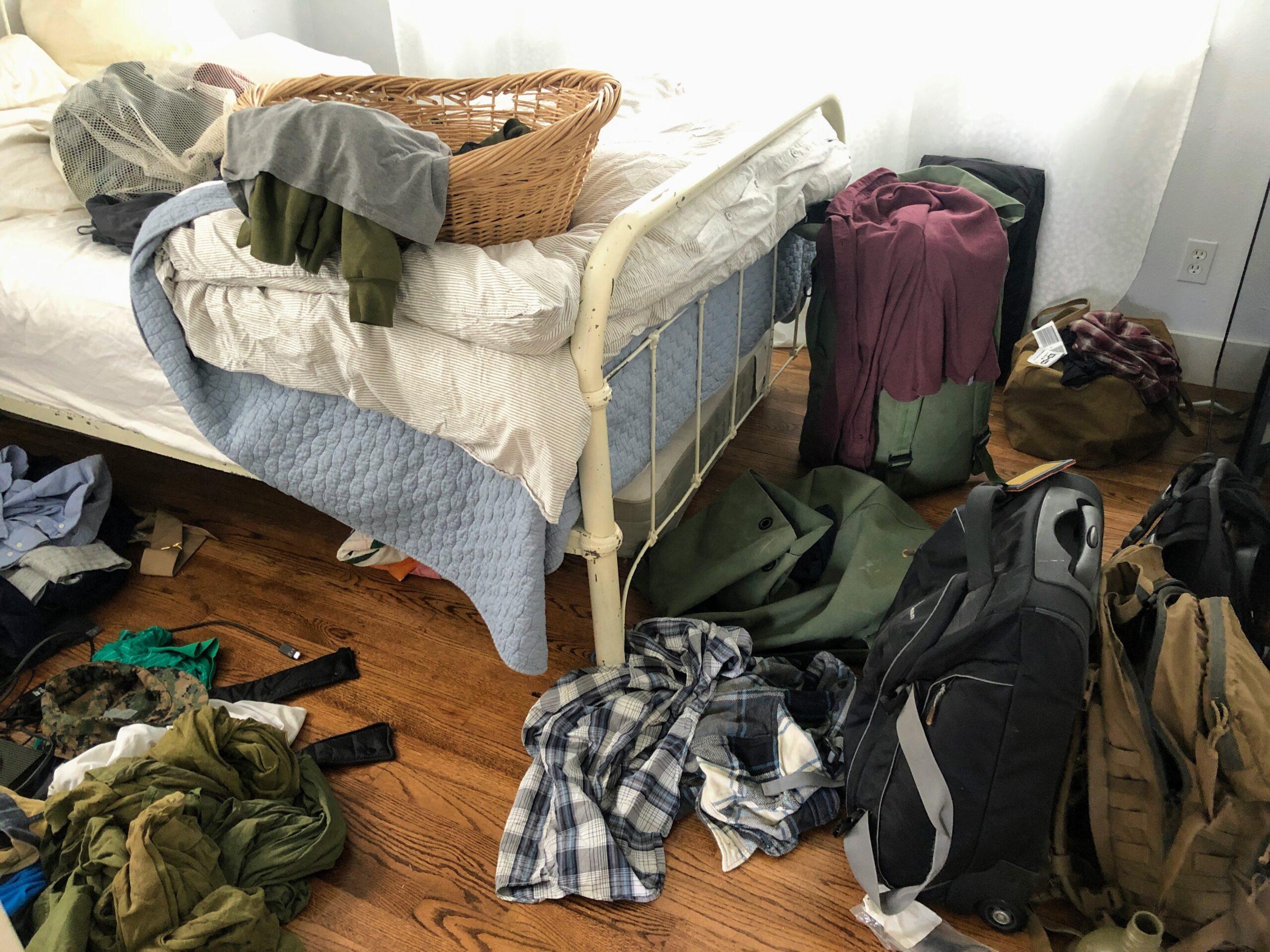 Bedroom strewn with clothing and other items.