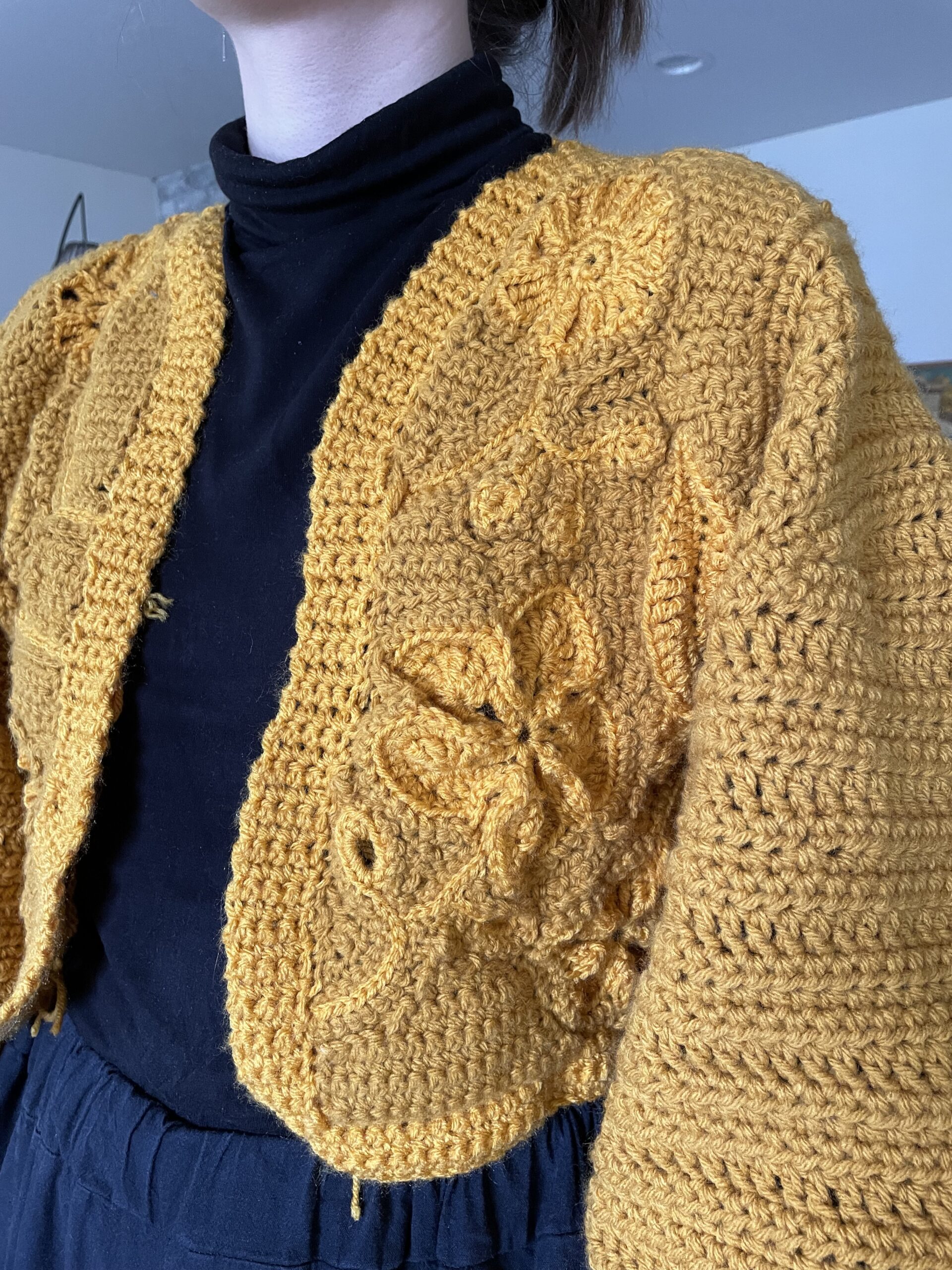 A hand-crocheted sweater with varied flowers in it. 