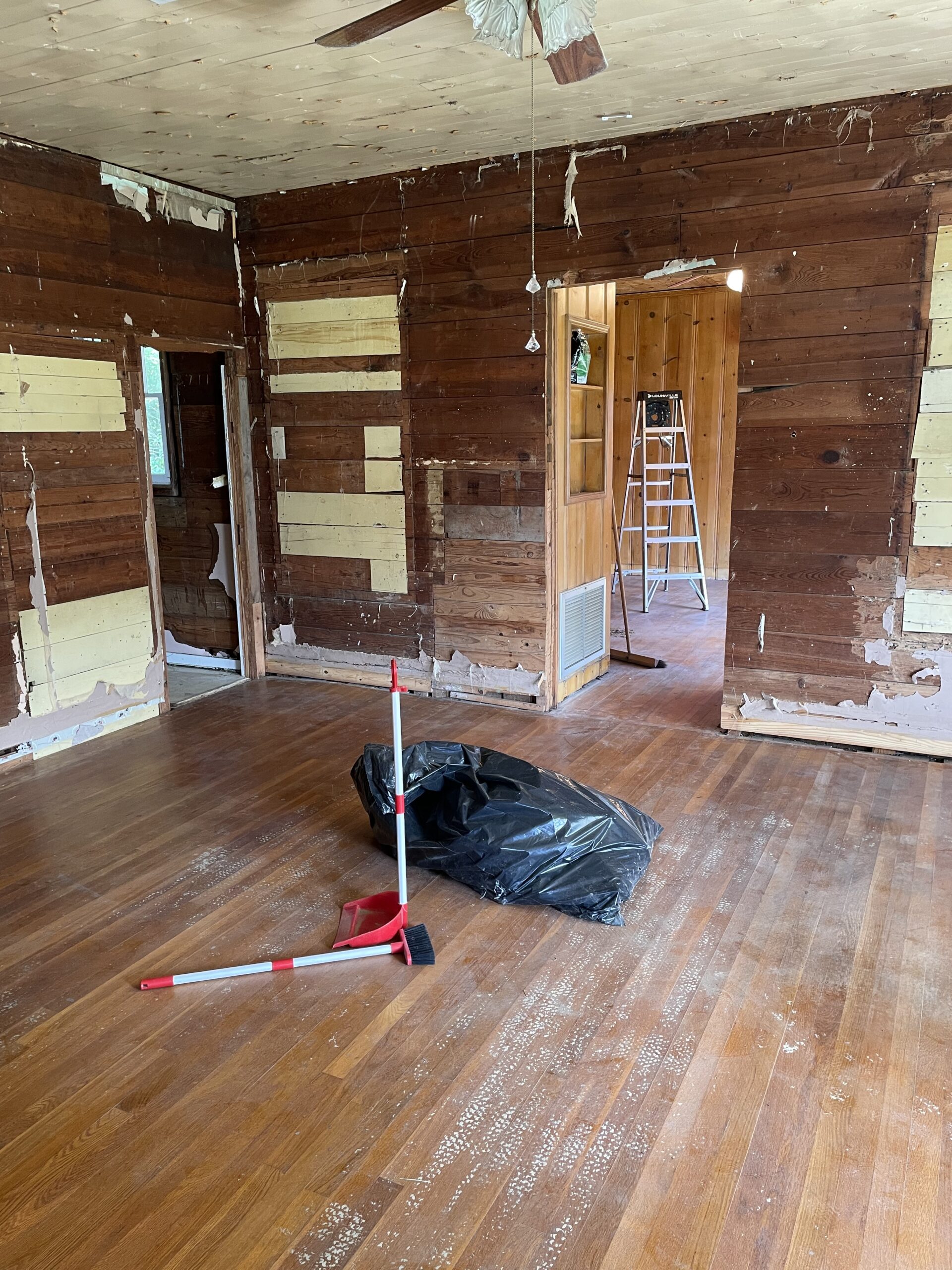 Image of a room with exposed wood walls and ceilings. Wood is not in good condition. 