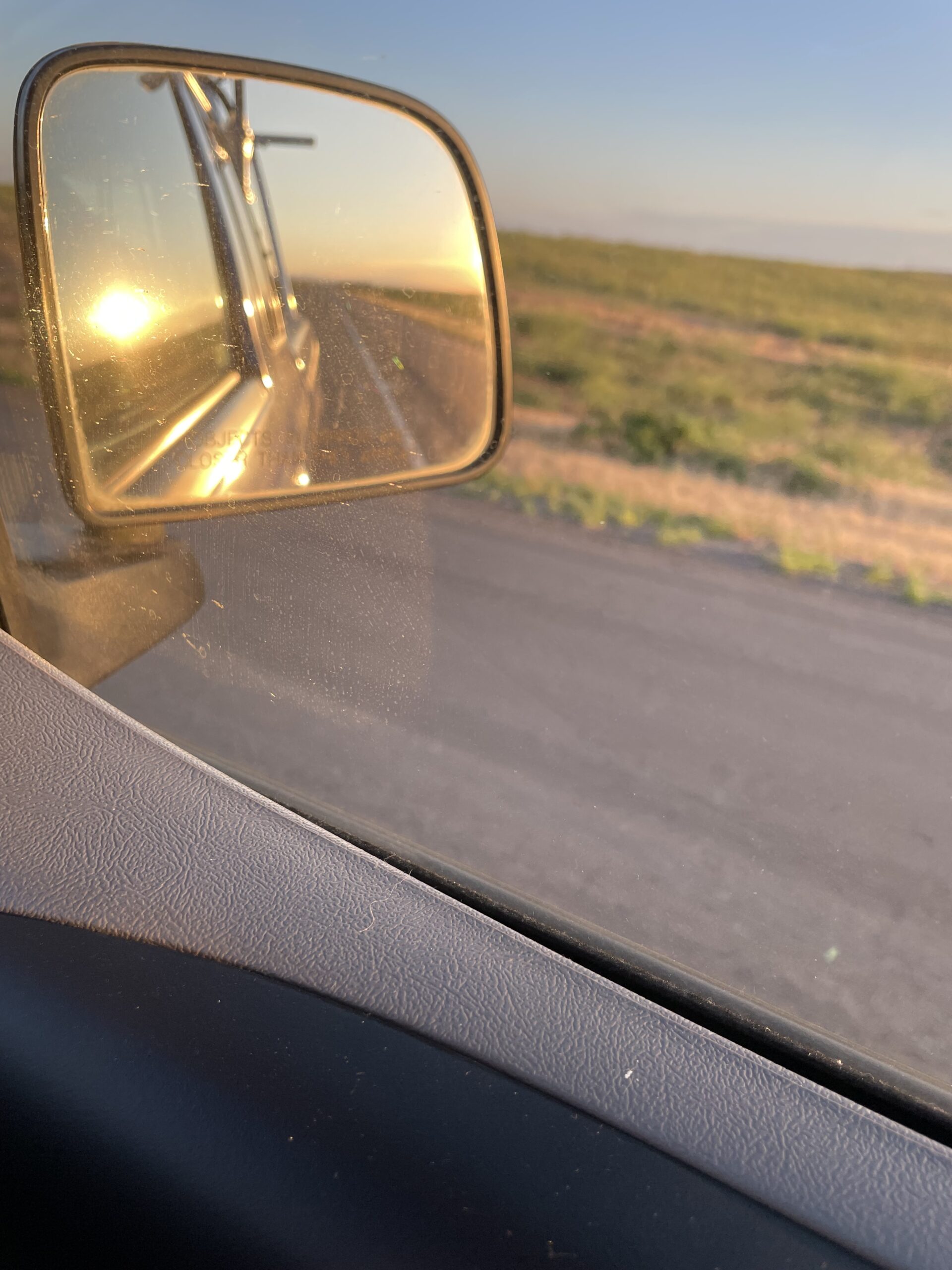Sun setting in rearview mirror